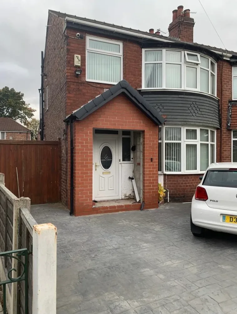 Red brick porch with a pitched tiled roof on a Manchester house