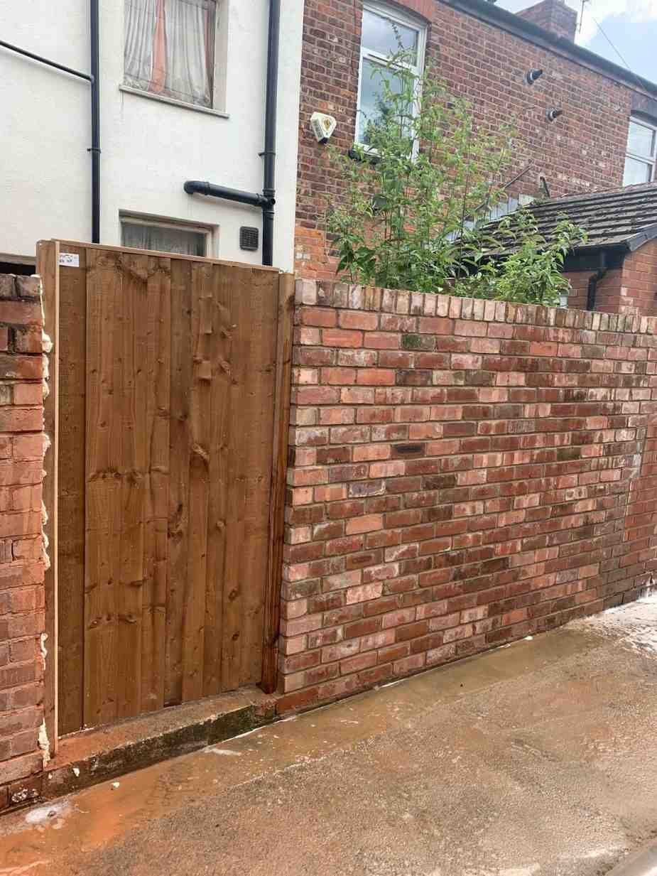 Brick wall with a timber gate, built by AJ Brickwork in Manchester