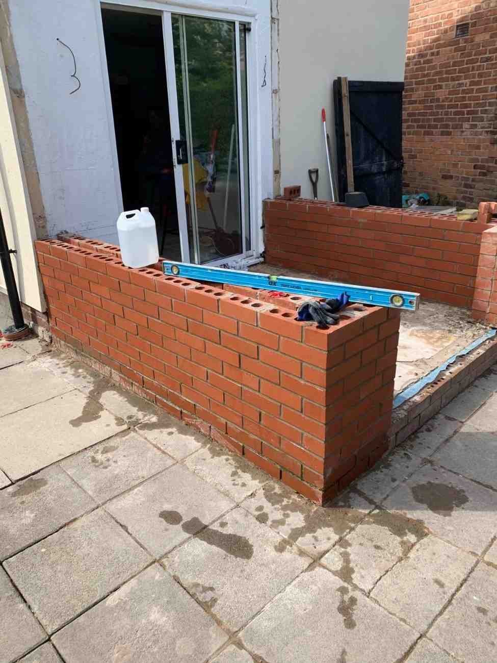 Brick wall alongside paving, built by AJ Brickwork in Manchester